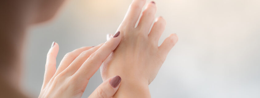 Closeup picture of a mature female's hands, she applying hand cr